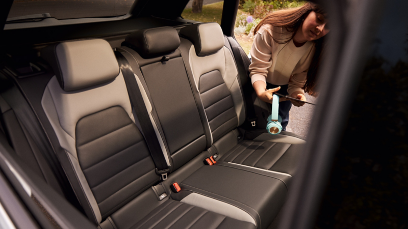 Vista dei sedili posteriori di Nuova Golf Variant, una donna sta per entrare in auto.